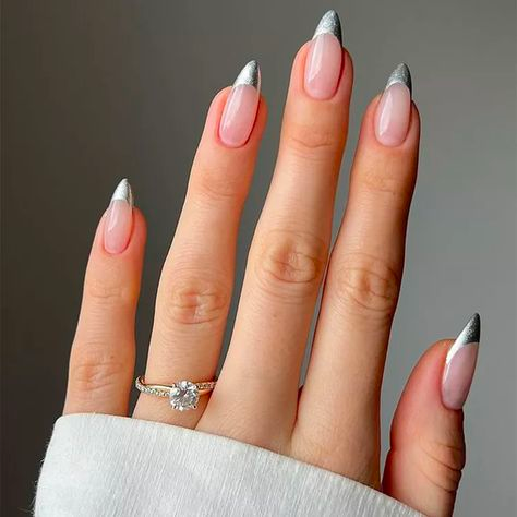 A woman's hand with newly painted nails, the tips pointed and metalic-looking