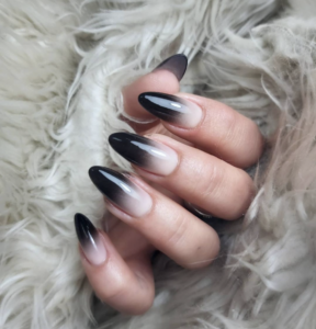 Woman's hand with black and white ombre nail design